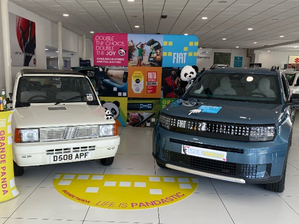 Two Fiat cars and panda decor in a showroom display.