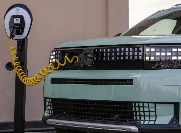 Electric car charging with a yellow cable connected to a front port.