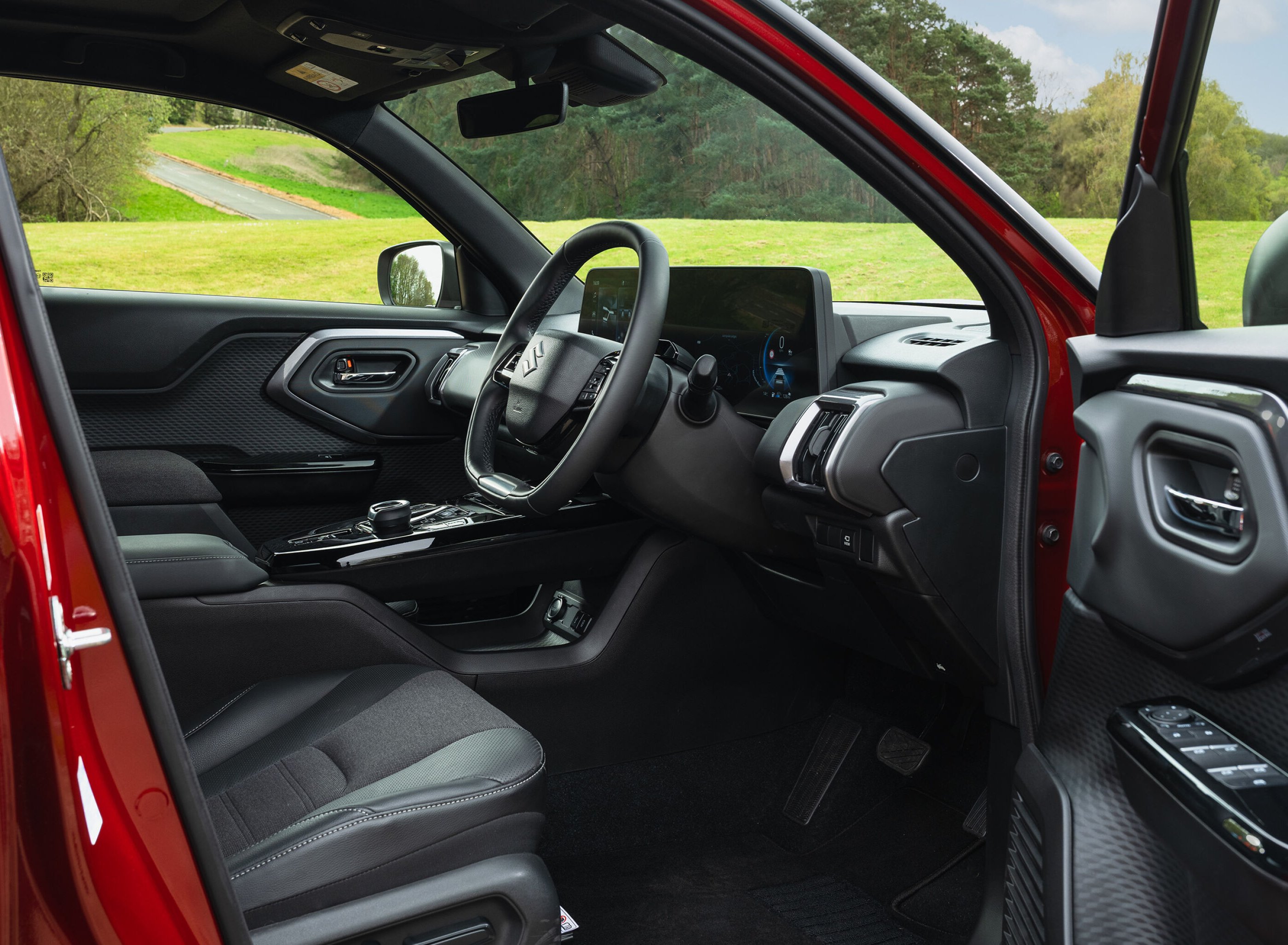 Interior of a red car showing steering wheel and dashboard.