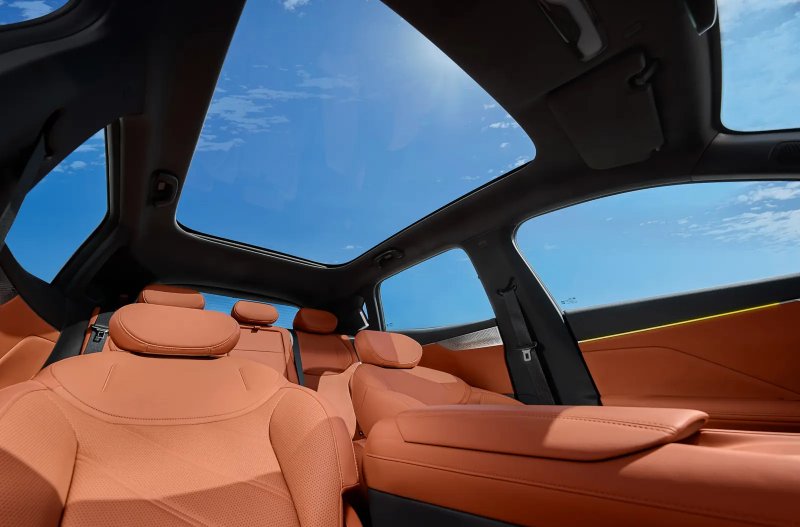 Car interior with brown leather seats and a panoramic sunroof.