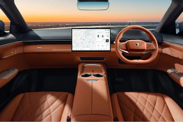 Luxury car interior with brown leather seats, modern steering wheel, and touchscreen display.