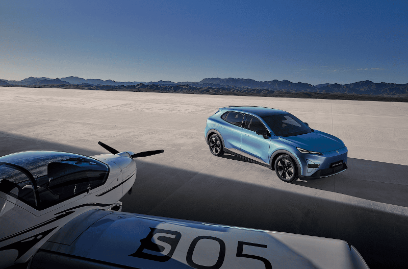 Blue SUV parked on a runway next to a small aircraft.