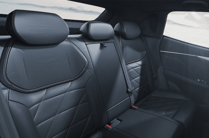 Rear seats of a car with black leather upholstery and seatbelt.