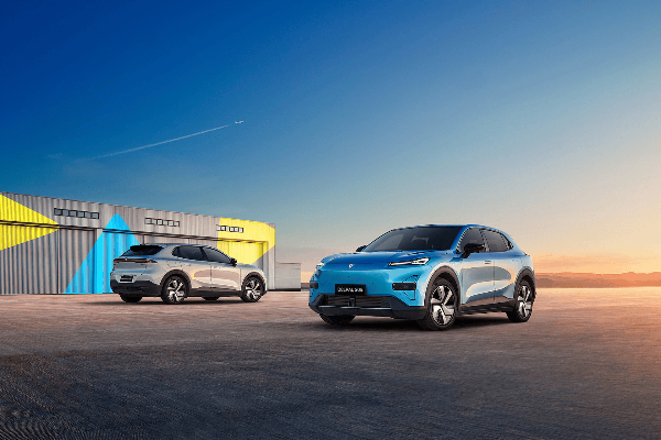 Two modern SUVs parked on a concrete surface under a clear sky.